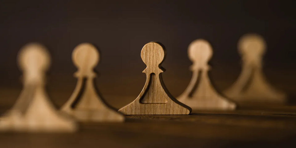 Professional wood chess pieces board displayed on an artist's easel in a gallery setting.