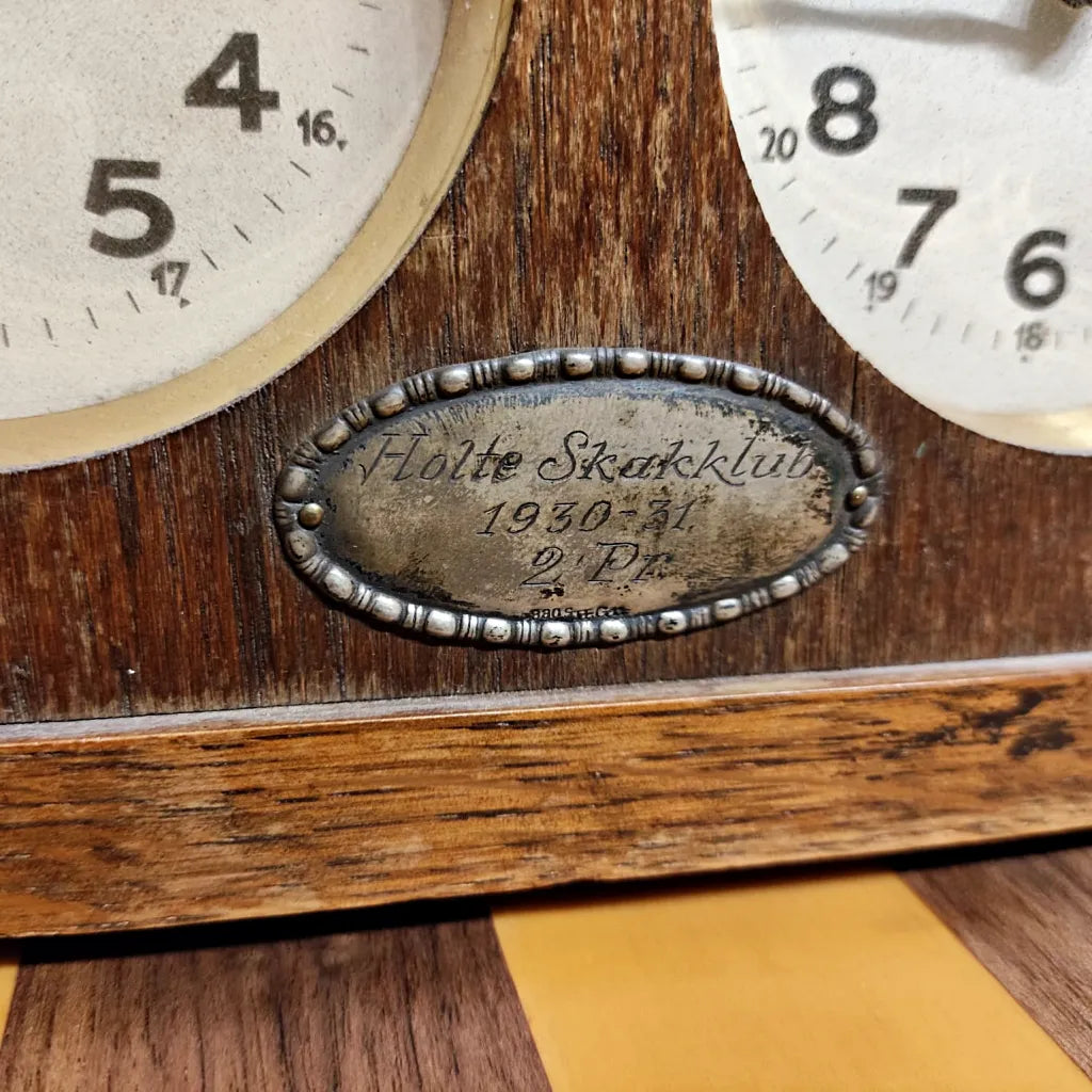 Macro shot of the silver engraved plaque on the chess clock reading "Holte Skakklub 1930-1931 2 Pr", documenting its Danish provenance.